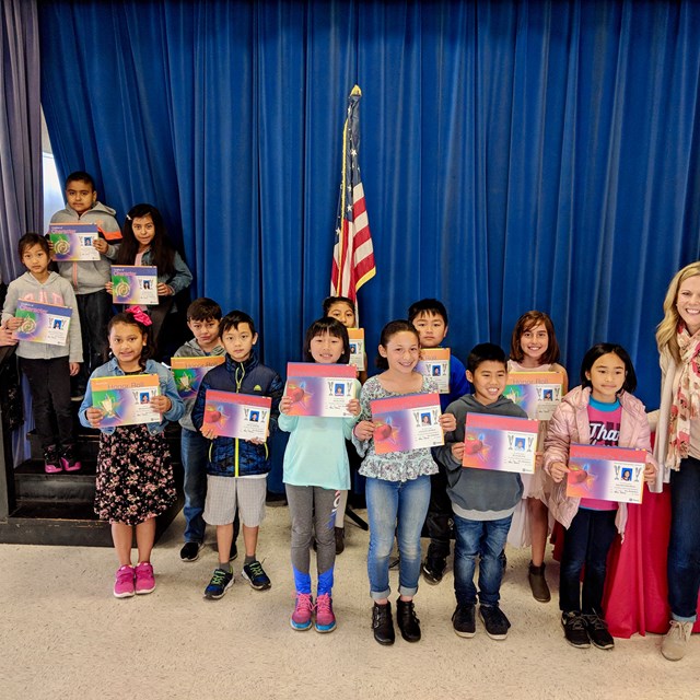 These students proudly display their awards for good character traits, honor roll, and principal's award.